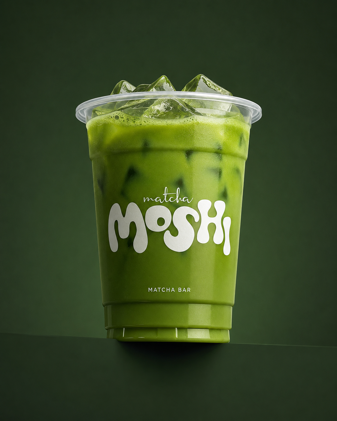Vaso de MOSHI MATCHA con matcha frío sobre fondo verde oscuro